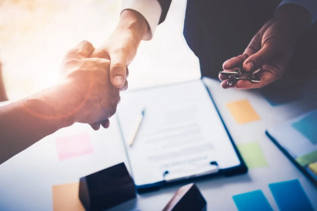 Handshake over a signed agreement on a clipboard
