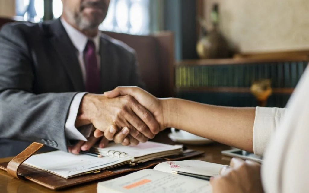 Handshake over a desk with an open planner