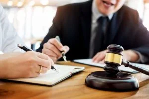 Lawyer and client taking notes beside a gavel